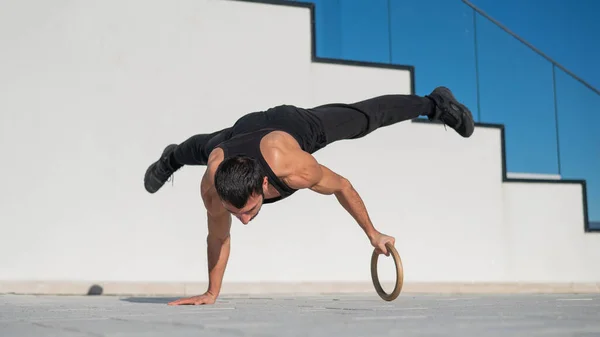 Een Man Zwarte Sportkleding Doet Een Acrobatische Handstand Een Ring — Stockfoto