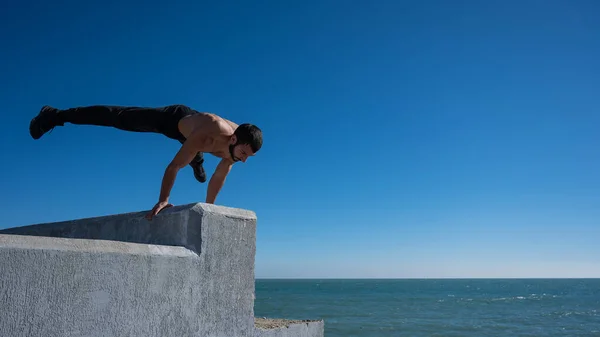 Ατρόμητος Άντρας Κάνει Κατακόρυφο Ένα Στηθαίο Δίπλα Στη Θάλασσα — Φωτογραφία Αρχείου