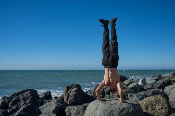 Ατρόμητος Άντρας Κάνει Κατακόρυφο Βράχους Δίπλα Στη Θάλασσα — Φωτογραφία Αρχείου