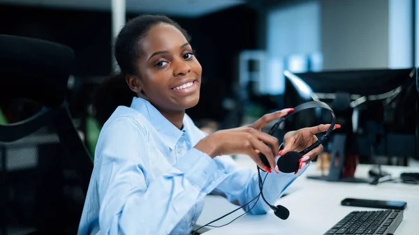 Mulher Jovem Africana Sorrindo Segurando Fone Ouvido Suas Mãos Funcionário — Fotografia de Stock