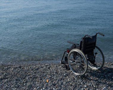 Kayalık bir sahilde boş bir tekerlekli sandalye.