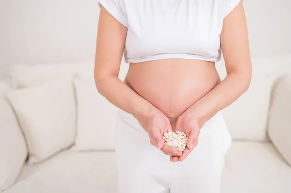 Těhotná Žena Bez Tváře Drží Hrst Bílých Pilulek — Stock fotografie
