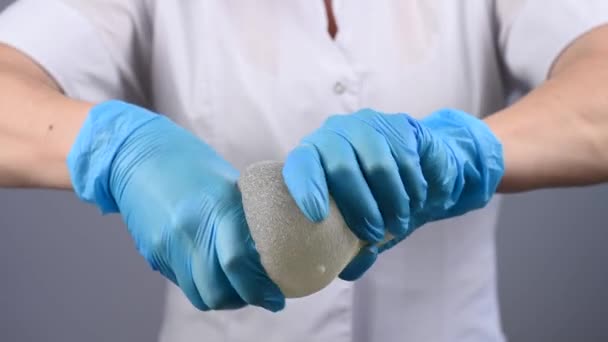 Plastikkirurg Visar Styrkan Silikonbröst Implantat Genom Att Klämma Dem — Stockvideo