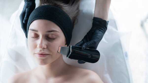 Вид сверху женщины на ультразвуковую чистку. Аппаратная косметология