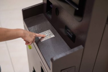 Yüzsüz kadın ATM 'de banka kartı şifresini çeviriyor.