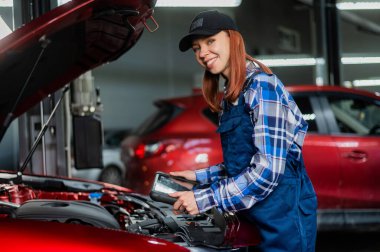 Kafkas kadın oto tamircisi hataları teşhis etmek için özel bir bilgisayar kullanıyor.