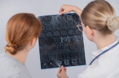 Kadın doktor, kadın hastaya iç organların MRI 'sını açıklıyor.