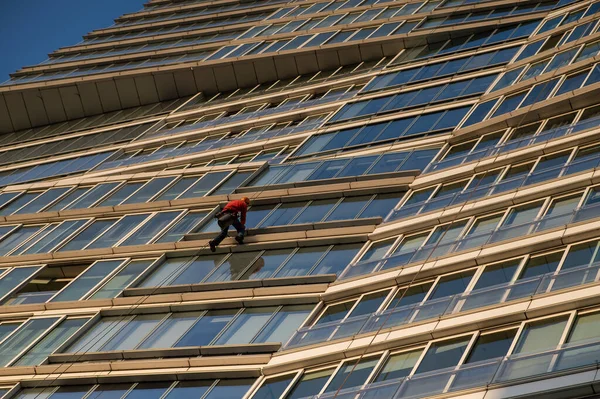 stock image A man washes the windows of a skyscraper. Industrial alpinism