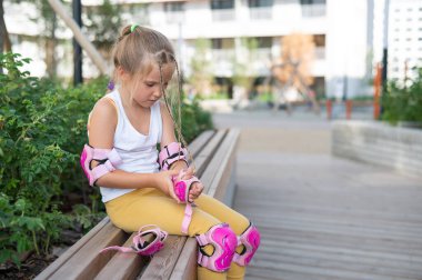 Küçük kız paten kaymayı dışarıda öğreniyor.