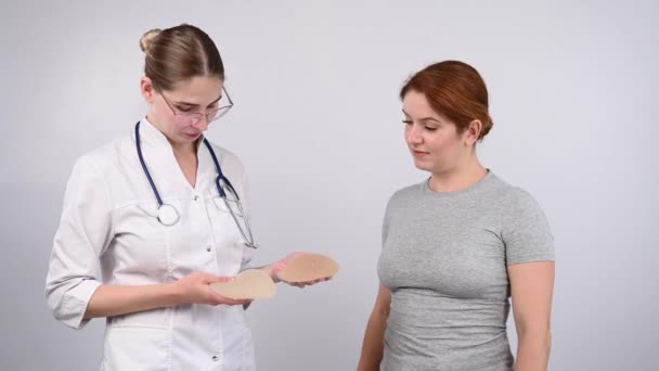 乳房インプラントを選ぶ白人女性と整形外科医 — ストック動画
