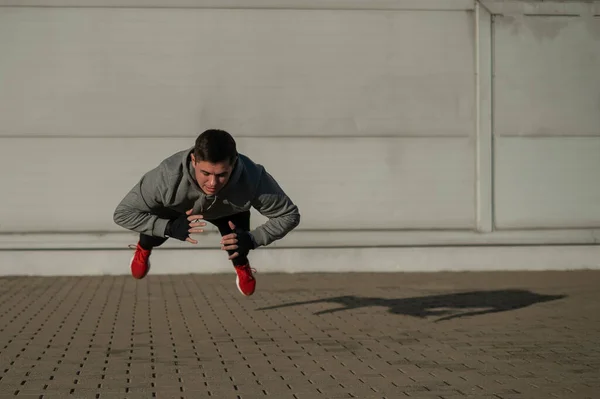 Mand Hættetrøje Springer Mens Han Laver Push Ups Udendørs - Stock-foto