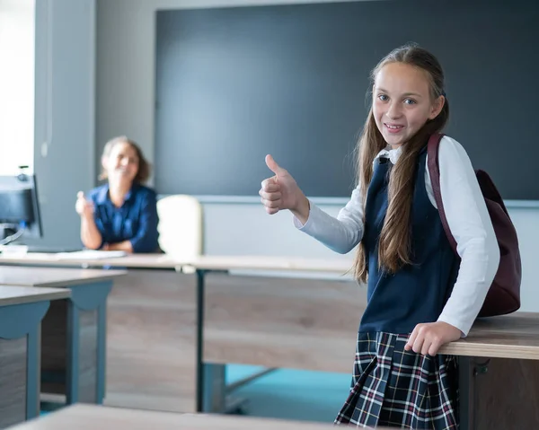 Blank Schoolmeisje Met Een Rugzak Een Vrouwelijke Leraar Klas Tonen — Stockfoto
