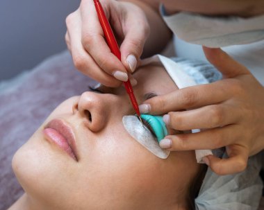 Kirpik boyama ve kaplama prosedüründen geçen genç bir kadın.