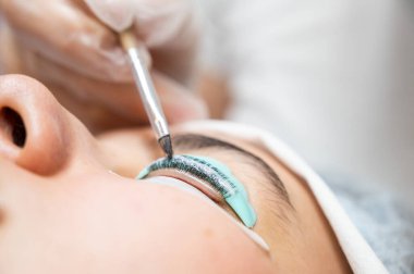 Kirpik kaplama prosedüründeki bir kadının yakın plan portresi