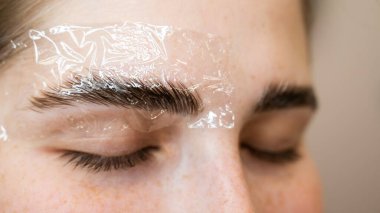 Kalıcı stil ve kaş boyama prosedürü üzerine beyaz kadın.