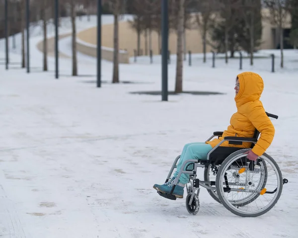 在冬季公园坐轮椅休息的妇女 — 图库照片