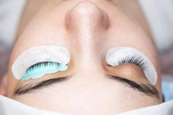 Close-up portrait of a woman in a beauty salon on eyelash lamination procedure