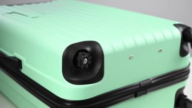 Bir kadın naneli plastik bir valizin kırık tekerleğini değiştiriyor. Bagaj çantası için değiştirilebilir donanım