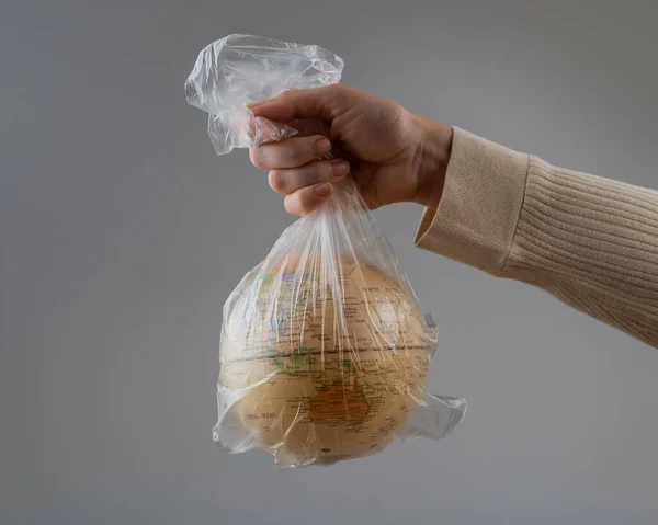 stock image A woman is holding a globe in a plastic bag on a white background