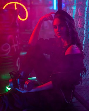 Neon Stüdyoda sis içinde poz veren beyaz bir kadın.