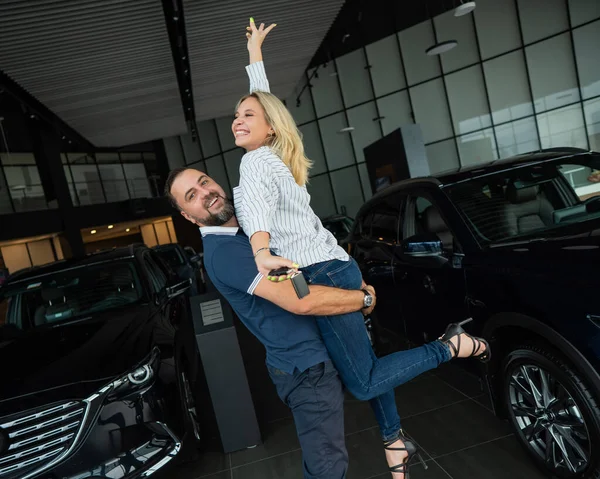 Feliz Casal Caucasiano Abraçando Enquanto Compra Carro Novo Uma Concessionária — Fotografia de Stock