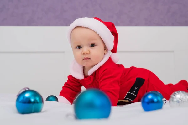 Chłopiec Przebrany Mikołaja Bawi Się Świątecznymi Dekoracjami Łóżku — Zdjęcie stockowe