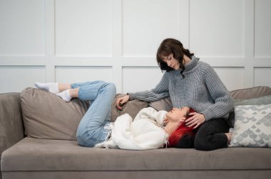 Genç kızlar kanepede yatarken sarılıyorlar. Tek cinsiyetli aşk