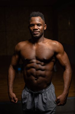 Karanlık bir stüdyoda çıplak gövdesi olan Afro-Amerikan bir adamın portresi. Kaslı adam.
