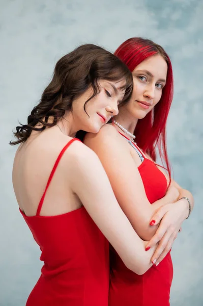 Retrato Close Duas Mulheres Abraçando Ternamente Vestidas Com Vestidos Vermelhos — Fotografia de Stock