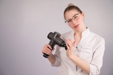 Masör doktor beyaz arka planda bir masör silahı tutuyor.