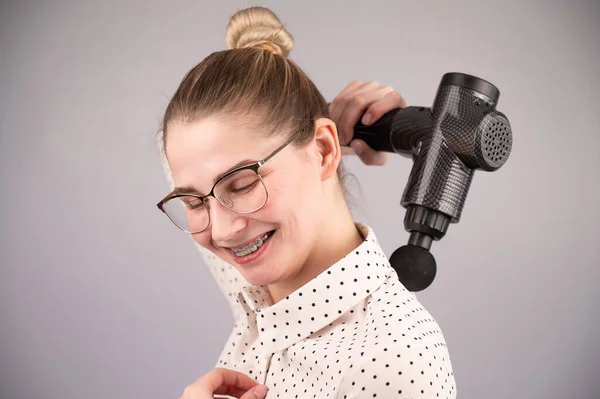 Lächelnde Frau Mit Zahnspange Benutzt Massagepistole Für Den Rücken — Stockfoto