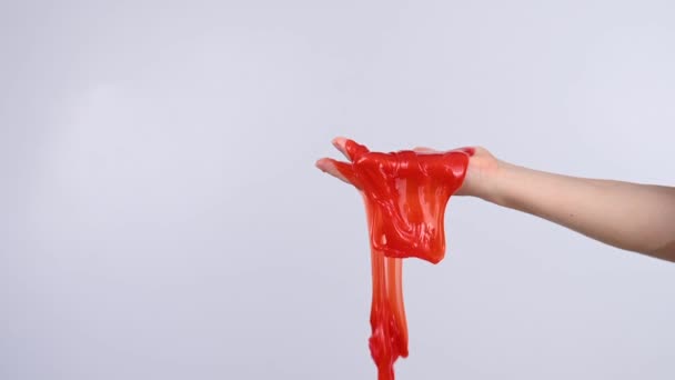 白い背景に女性の手から流れる赤いスライム — ストック動画