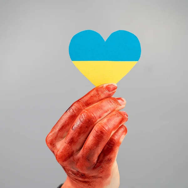 白地にウクライナの旗を胸に手を血で覆っている女性 — ストック写真