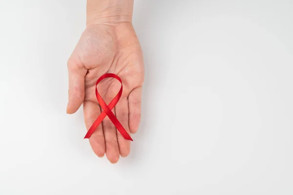 Kobieca Dłoń Czerwoną Wstążką Białym Tle Symbol Walki Aids Przestrzeń — Zdjęcie stockowe
