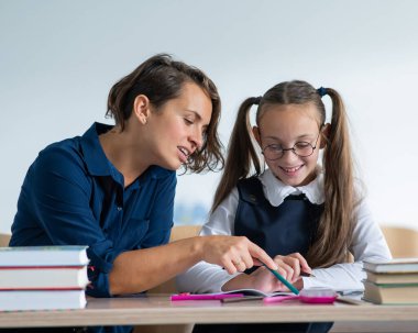 Öğretmen sınıftaki öğrenciye görevi açıklar.