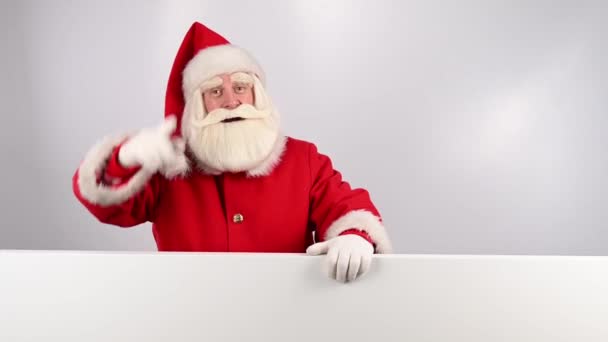サンタクロースは白い背景の広告の後ろからのぞき見します メリークリスマス — ストック動画