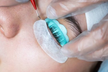 Usta kirpikleri kaplamak için çok fonksiyonlu bir araç kullanır