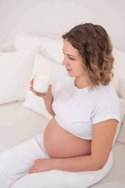 임신부가 소파에 우유를 마신다 — 스톡 사진