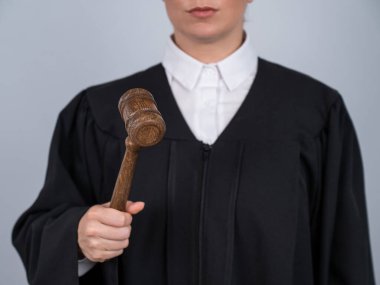 Elinde mahkeme tokmağı tutan bornozlu kadın yargıç.