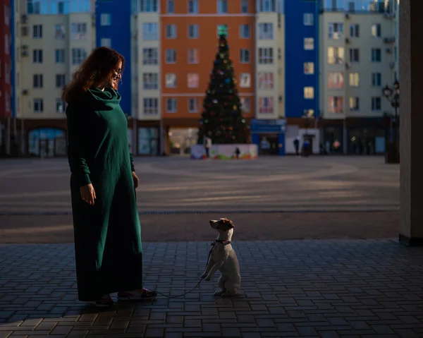 Рыжая Женщина Зеленом Платье Собакой Джеком Расселом Терьером Площади Фоне — стоковое фото