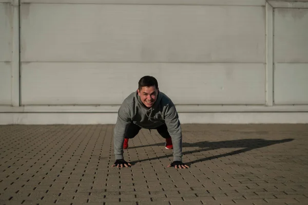 Man Hoodie Jumps While Doing Push Ups Outdoors — Stock Photo, Image
