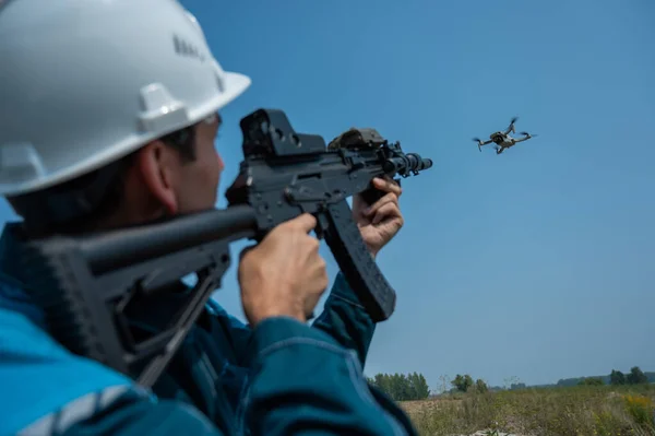 Biały Mężczyzna Kasku Strzela Latającym Dronem Strzelby — Zdjęcie stockowe