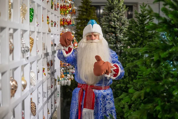 俄罗斯圣诞老人为商店的圣诞树挑选装饰品 — 图库照片