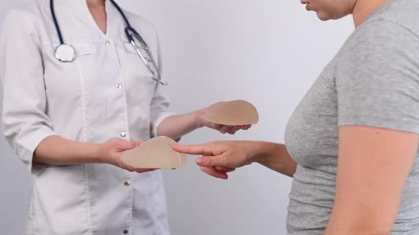 乳房インプラントを選ぶ白人女性と整形外科医 — ストック動画