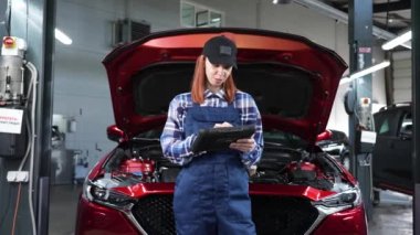 Kafkas kadın oto tamircisi hataları teşhis etmek için özel bir bilgisayar kullanıyor.