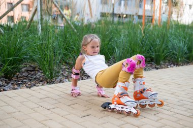 Küçük bir kız ve annesi açık hava spor sahasında briç oynuyorlar.