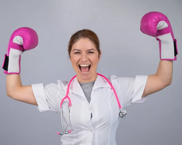 A female doctor raised her hands in pink boxing gloves as a sign of victory over the disease