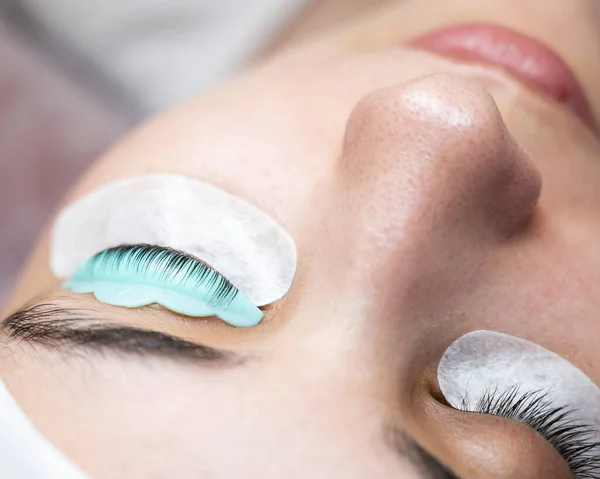 Close-up portrait of a woman in a beauty salon on eyelash lamination procedure