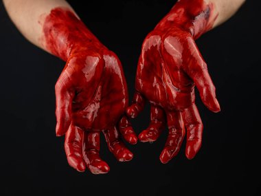 Siyah bir arka planda kanlı kadın elleri