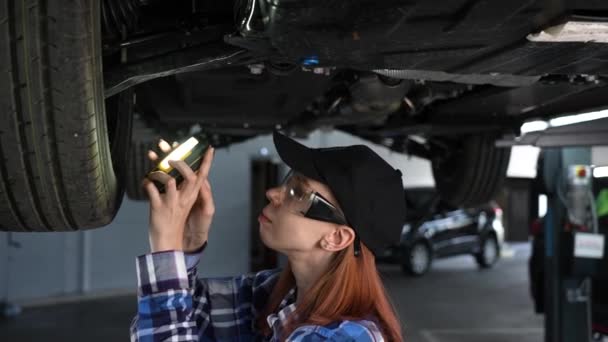 Female Mechanic Inspects Lifted Car Girl Mans Work — Stock Video